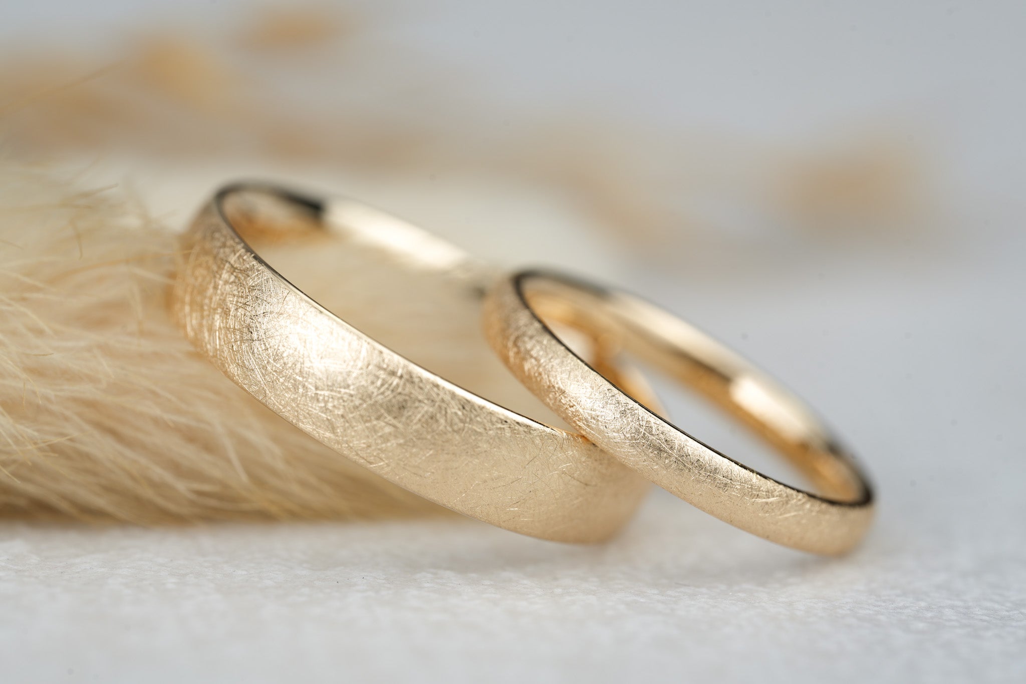 Trauringe Gold matt in ovaler Form mit Eismatter Oberflaeche