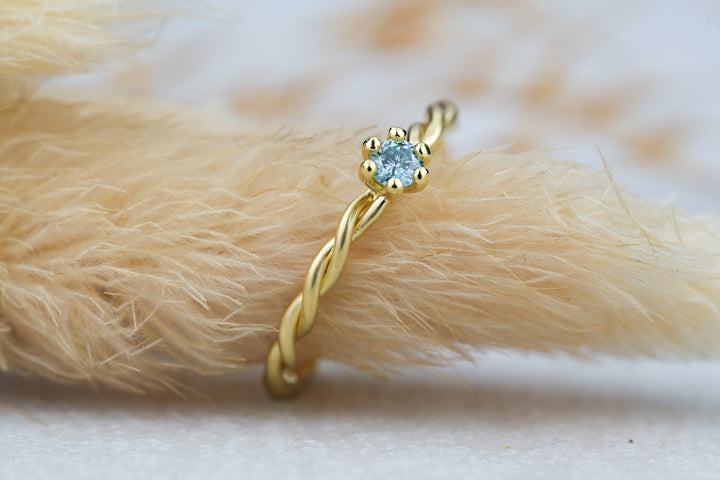 gedrehter Verlobungsring mit blauen Diamant