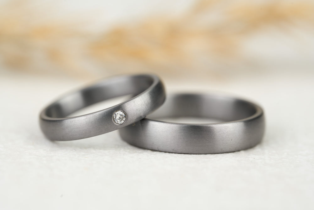 besondere Eheringe aus Tantal mit Diamant im Damenring